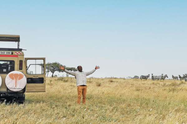 Glücklicher Guide mit einem Land Cruiser