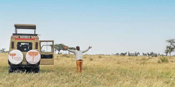 Glücklicher Guide mit einem Land Cruiser